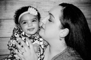 Photo: black and white photo of mother kissing her smiling baby
