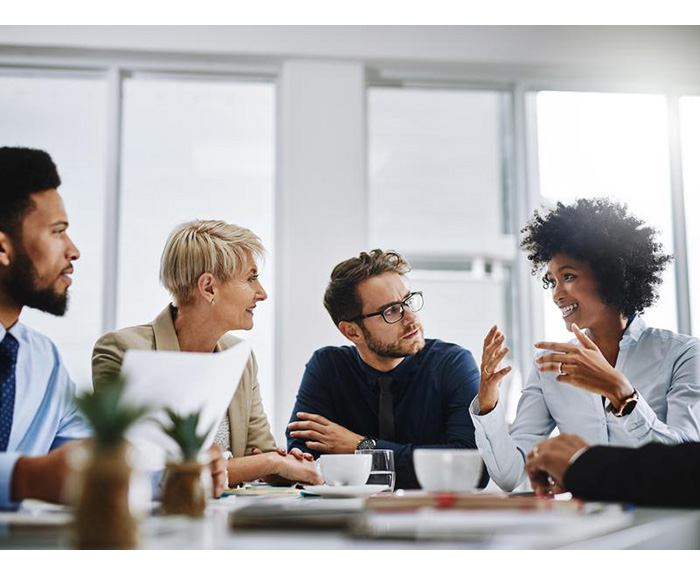 four people sitting around a table having a conversation