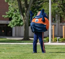 Otto the Orange in a mask on quad