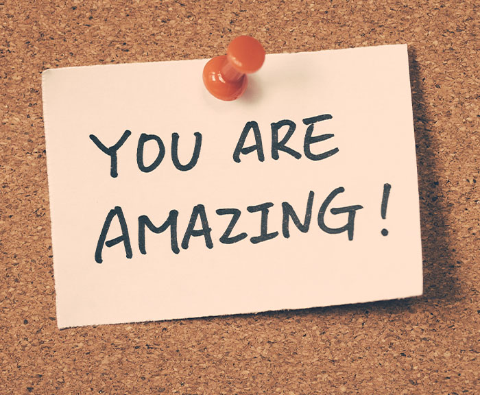 A note with the words You are amazing on a cork board